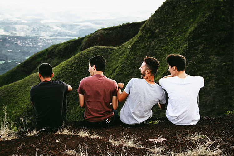 friends sitting on the edge of a cliff