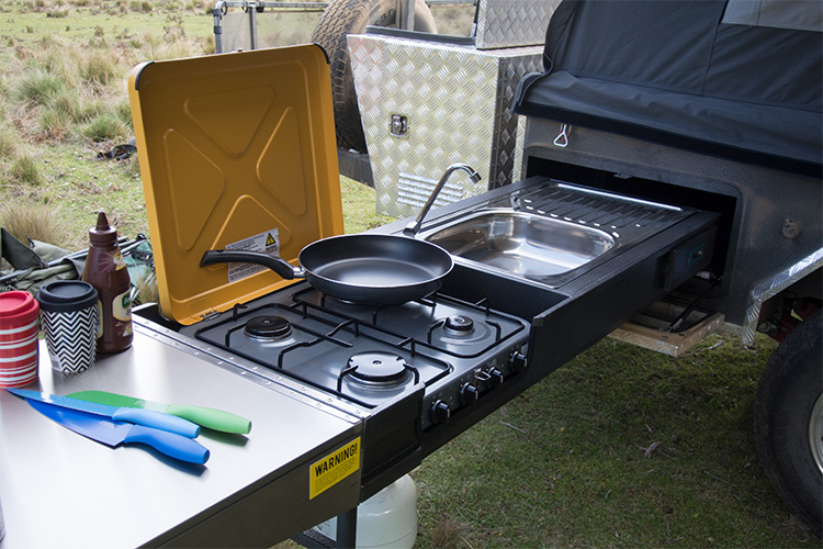 A camper trailer with a pull out 4 burner cook top