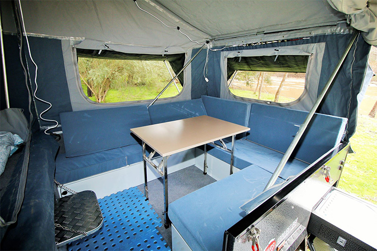 Camper trailer with a fold-up table and couch 