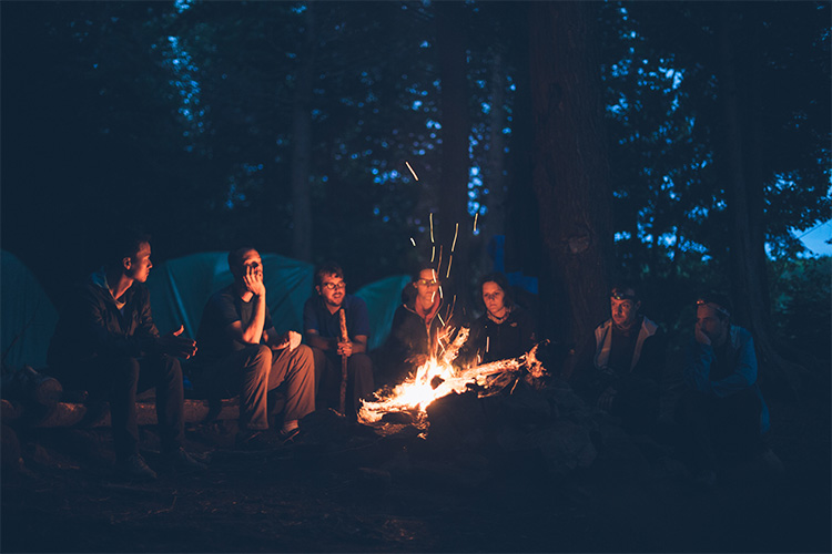 friends sitting around bonfire