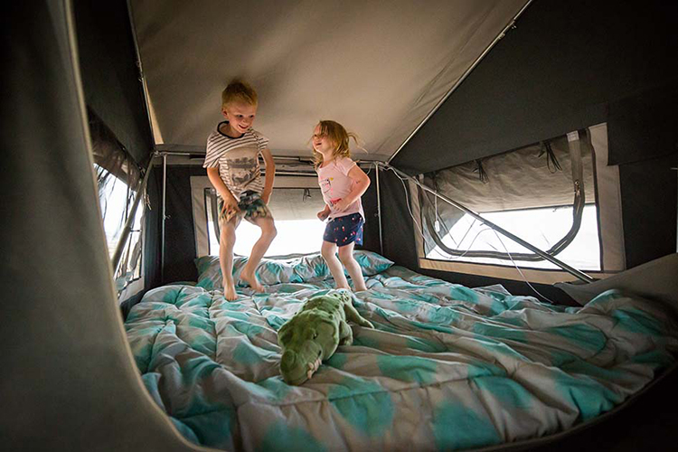 kids jumping in a camper